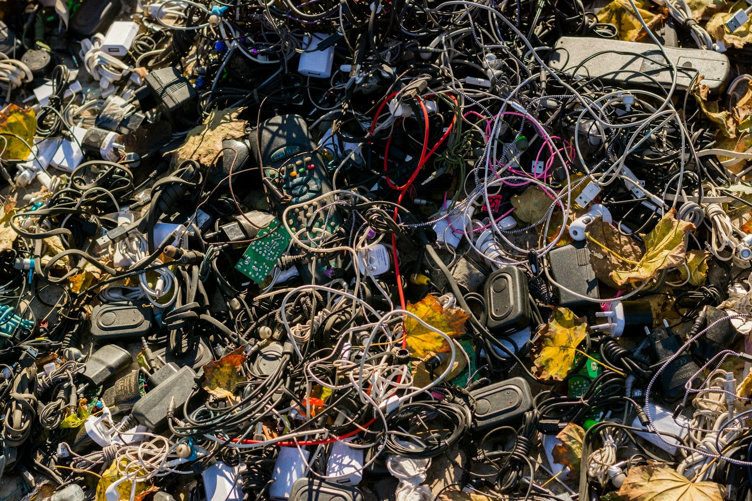Affald fra elektroniske enheder, herunder gamle smartphones, laptops og kabler, samlet til genbrug for at reducere skadelige stoffer og genvinde værdifulde materialer.