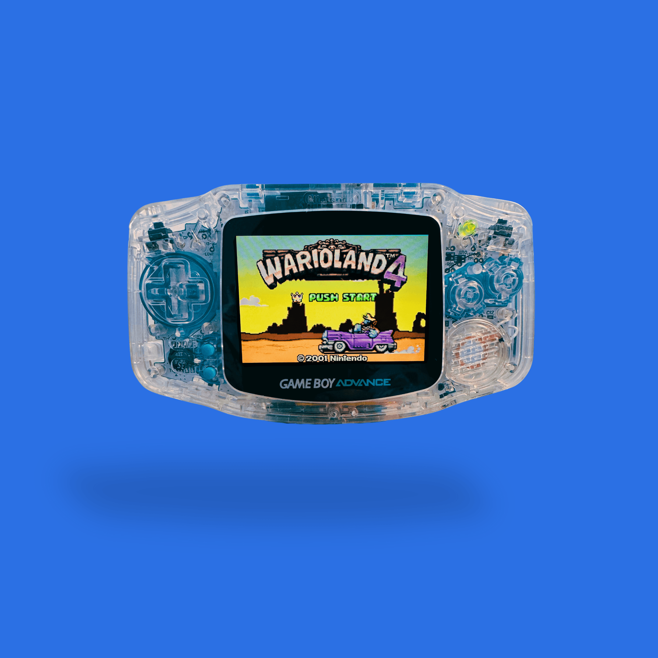 En RetroGear-moddet gennemsigtig Nintendo Game Boy Advance med blå detaljer og spillet Wario Land 4 synligt på skærmen.